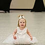 Chloe is registered to the contest to win money with this photo: toddler, child, white_dress, bow, sitting, floor, indoor, curious, smile, blonde_hair, young_child, portrait, cute, fashion, girl, innocence, soft_lighting, background_blur, person, baby