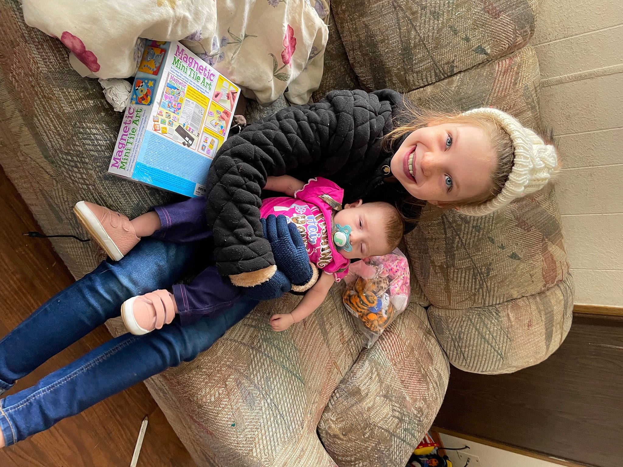 Aria is registered to the contest to win money with this photo: baby, baby_products, baby_toddler_clothing, child, comfort, flooring, foot, fun, happy, joy, lap, leg, leisure, person, room, sitting, skin, smile, sock, thigh