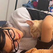 Nala is registered to the contest to win money with this photo: bedroom, black_hair, blanket, casual_clothing, cat, comfort, cozy, desk, glasses, home, hugging, indoor, intimate, orange_cat, person, plush_toy, relaxing, resting, sleeping, soft_lighting