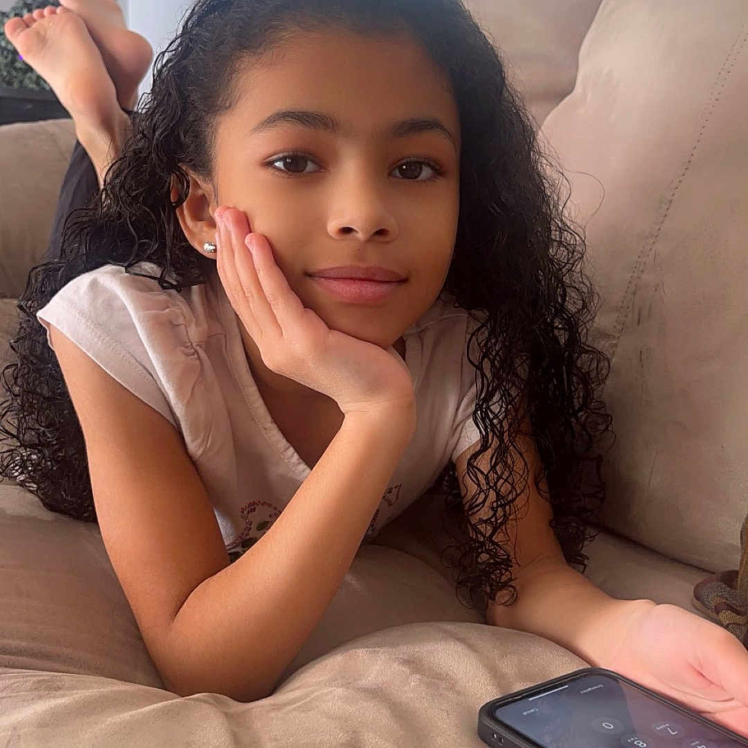 Payton joined the competition — help win amazing prizes! blackhair, child, clothing, curlyhair, dimples, electronics, face, female, girl, hair, happy, head, mobilephone, person, phone, photography, sad, selfie, sleeve, smile