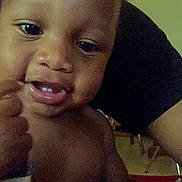 Legend is registered to the contest to win money with this photo: child, baby, face, skin, expression, indoor, person, hand, mouth, eye, curious, closeup, portrait, infant, young, dark_skin, fingertip, background, blur, room