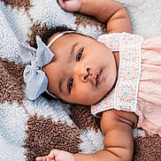 Graice joined the competition — help win amazing prizes! baby, infant, child, portrait, lying_down, blanket, bow, headband, pink_outfit, pastel, smiling, wide_eyes, face, arms, hands, bracelet, indoor, close_up, cozy, photography