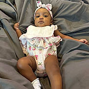 Amaya is registered to the contest to win money with this photo: baby, blanket, child, clothing, comfortable, cute, expression, headband, indoors, infant, lying_down, pattern, pink, portrait, relaxed, skin, socks, soft, strawberry, white