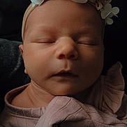 Milana joined the competition — help win amazing prizes! baby, newborn, infant, sleeping, headband, flower_headband, flowers, closed_eyes, portrait, close_up, soft_lighting, pink_clothing, swaddle, cozy, peaceful, skin, face, cheeks, nose, ruffle