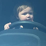 Armani is registered to the contest to win money with this photo: car_interior, casual, child, closeup, curious, daylight, driving, face, hands, head, indoor, person, portrait, reflection, serious_expression, steering_wheel, toddler, vehicle, window, young_child