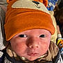 baby, blanket, child, close_up, clothing, cute, expression, eyes, face, hat, headwear, indoors, infant, mouth, newborn, orange_hat, person, portrait, skin, wrapped