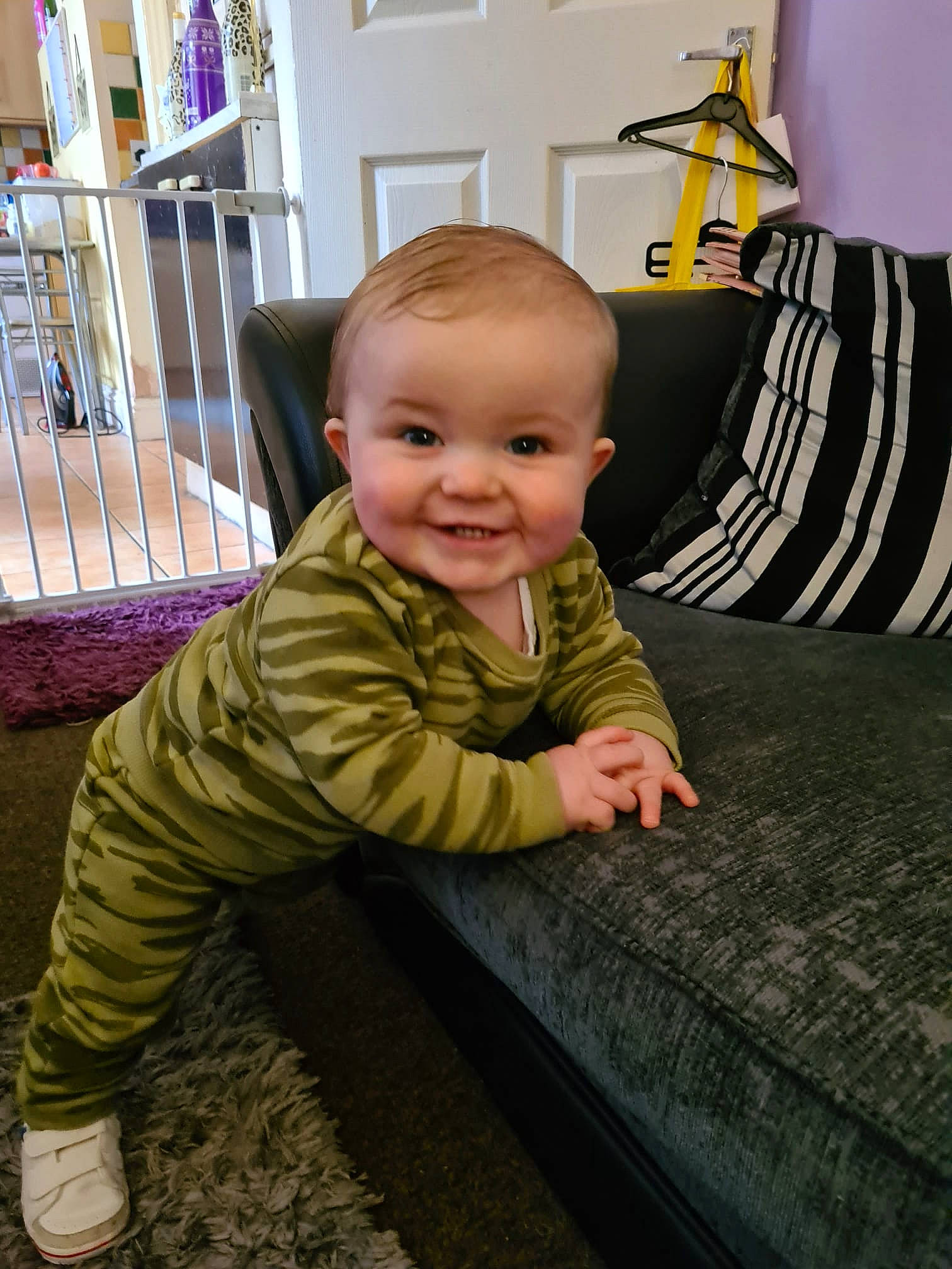 Casper is registered to the contest to win money with this photo: baby, baby_toddler_clothing, carpet, cheek, child, door, fence, floor, flooring, fun, grass, hardwood, joy, pattern, person, room, sitting, sleeve, smile, toddler
