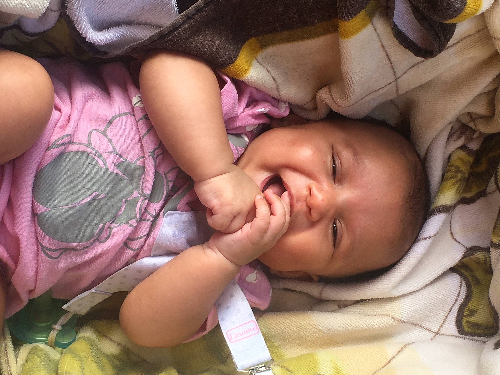 Alexia is registered to the contest to win money with this photo: baby, cheek, comfort, eye, facial_expression, finger, hairstyle, human, iris, lip, mammal, mouth, nose, person, pink, product, purple, skin, smile, textile