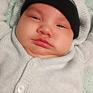 Josiahhawk joined the competition — help win amazing prizes! baby, infant, face, headwear, hat, beanie, clothing, sweater, blanket, lying_down, expression, chubby_cheeks, indoor, portrait, skin, person, child, young, cute, screenshot