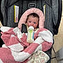 baby, infant, car_seat, blanket, bottle, feeding, face, person, indoors, floor_tiles, pink, white, gray, clothing, newborn, cute, child, soft_texture, wrapped, captive