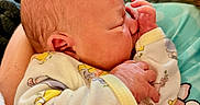 Saige is registered to the contest to win money with this photo: newborn, baby, infant, sleeping, portrait, face, hands, onesie, clothing, blanket, cuddled, cozy, indoors, close_up, seated, soft_lighting, patterned, family, child, photograph