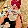 Saige is registered to the contest to win money with this photo: newborn, baby, sleeping, infant, portrait, bow, headband, pink, onesie, clothing, bulldog, logo, white, black, socks, arms, hands, carpet, slippers, indoor