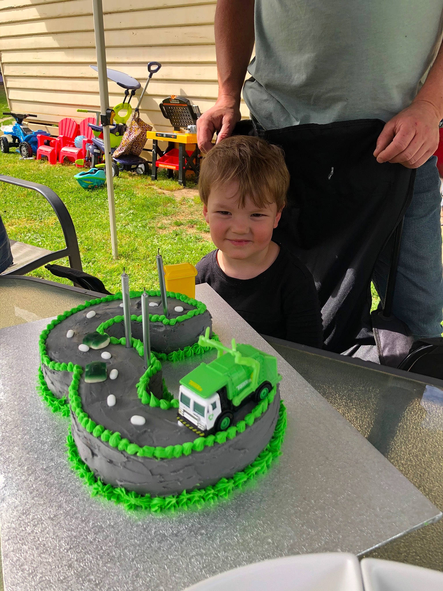 Oscar is registered to the contest to win money with this photo: baked_goods, birthday_cake, buttercream, cake, cake_decorating, dessert, food, icing, joy, person, play, race_track, sugar_paste, torte, vehicle