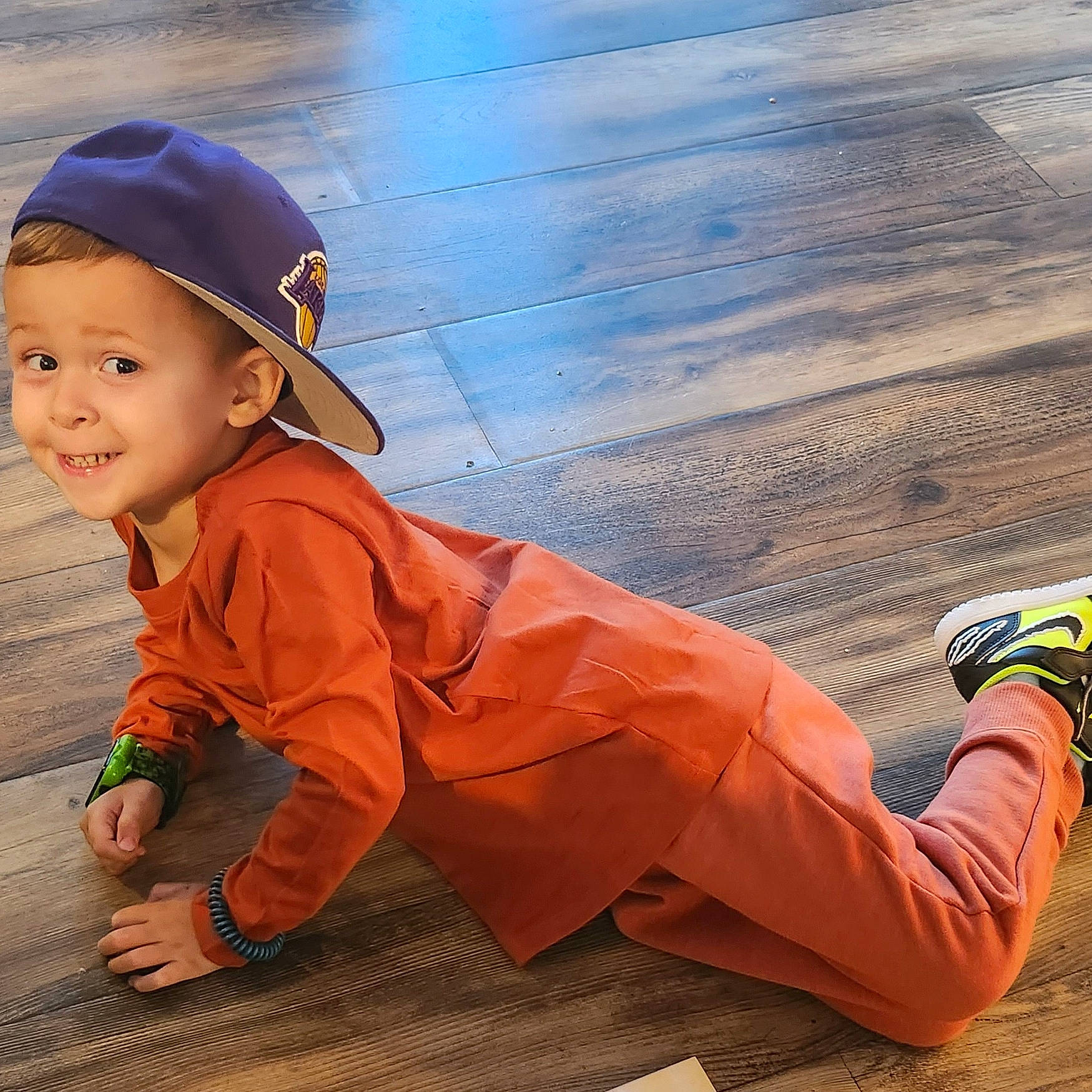 Joshua is registered to the contest to win money with this photo: asphalt, floor, flooring, footwear, happy, headwear, human_leg, landscape, leg, leisure, orange, people, people_in_nature, person, road_surface, smile, sneakers, standing, toddler, travel