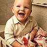 baby, child, toddler, smiling, laughing, portrait, indoor, basket, blanket, cozy, seated, clothing, shirt, face, eyes, mouth, furniture, home, warm_lighting, happy