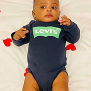 Dayvan participe au concours pour gagner de l'argent avec cette photo : baby, infant, onesie, levis_logo, bed, bedding, heart_pattern, portrait, face, hands, legs, young_child, cute, adorable, lying_down, indoor, blanket, skin, curious_expression, baby_photography