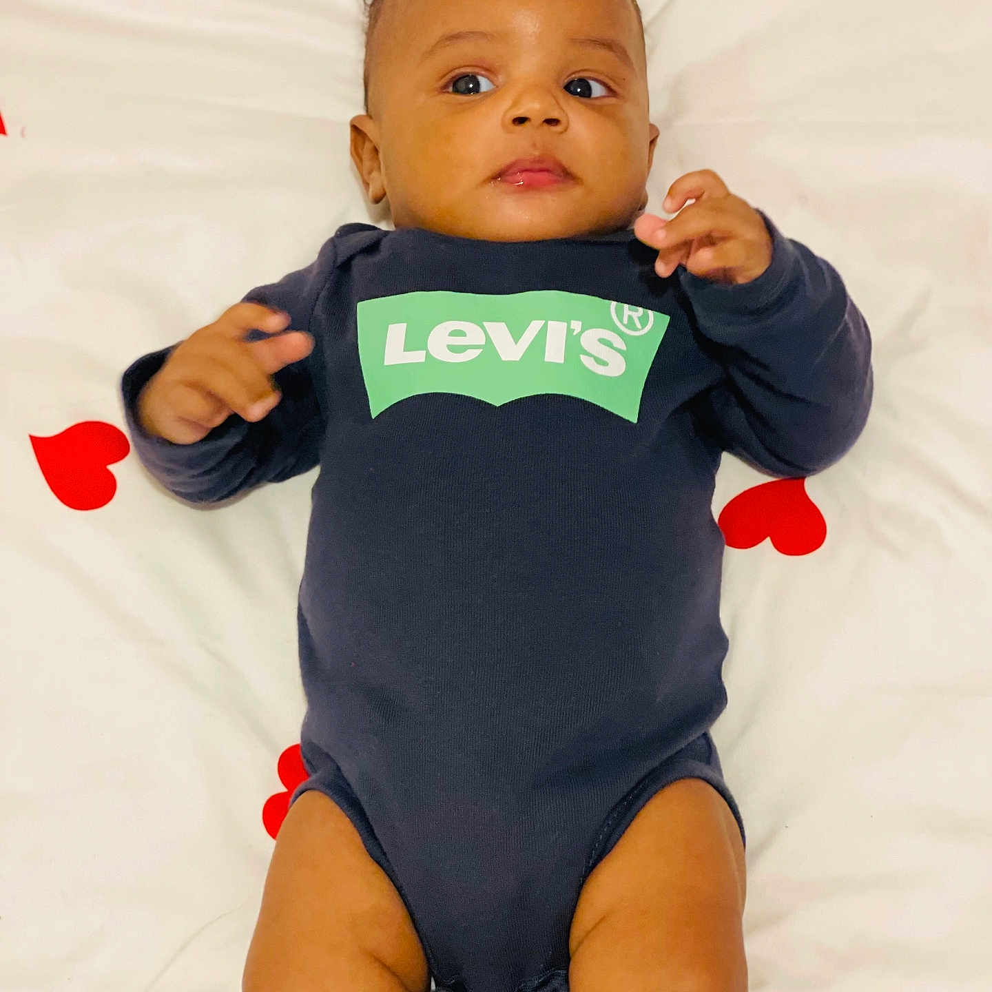 Dayvan participe au concours pour gagner de l'argent avec cette photo : adorable, baby, baby_photography, bed, bedding, blanket, curious_expression, cute, face, hands, heart_pattern, indoor, infant, legs, levis_logo, lying_down, onesie, portrait, skin, young_child