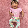 Giovanna joined the competition — help win amazing prizes! baby, infant, child, smiling, lying_down, portrait, floral_outfit, pink_clothing, headband, bow, blanket, pink_blanket, indoors, cute, happy, face, hands, feet, fashion, text_on_clothing