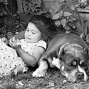 Athena a rejoint le concours — aidez-le/la à gagner de superbes lots ! child, dog, black_and_white, outdoor, grass, tree, foliage, resting, lying_down, pet, collar, nature, relaxation, cute, young_child, animal, companion, peaceful, portrait, casual