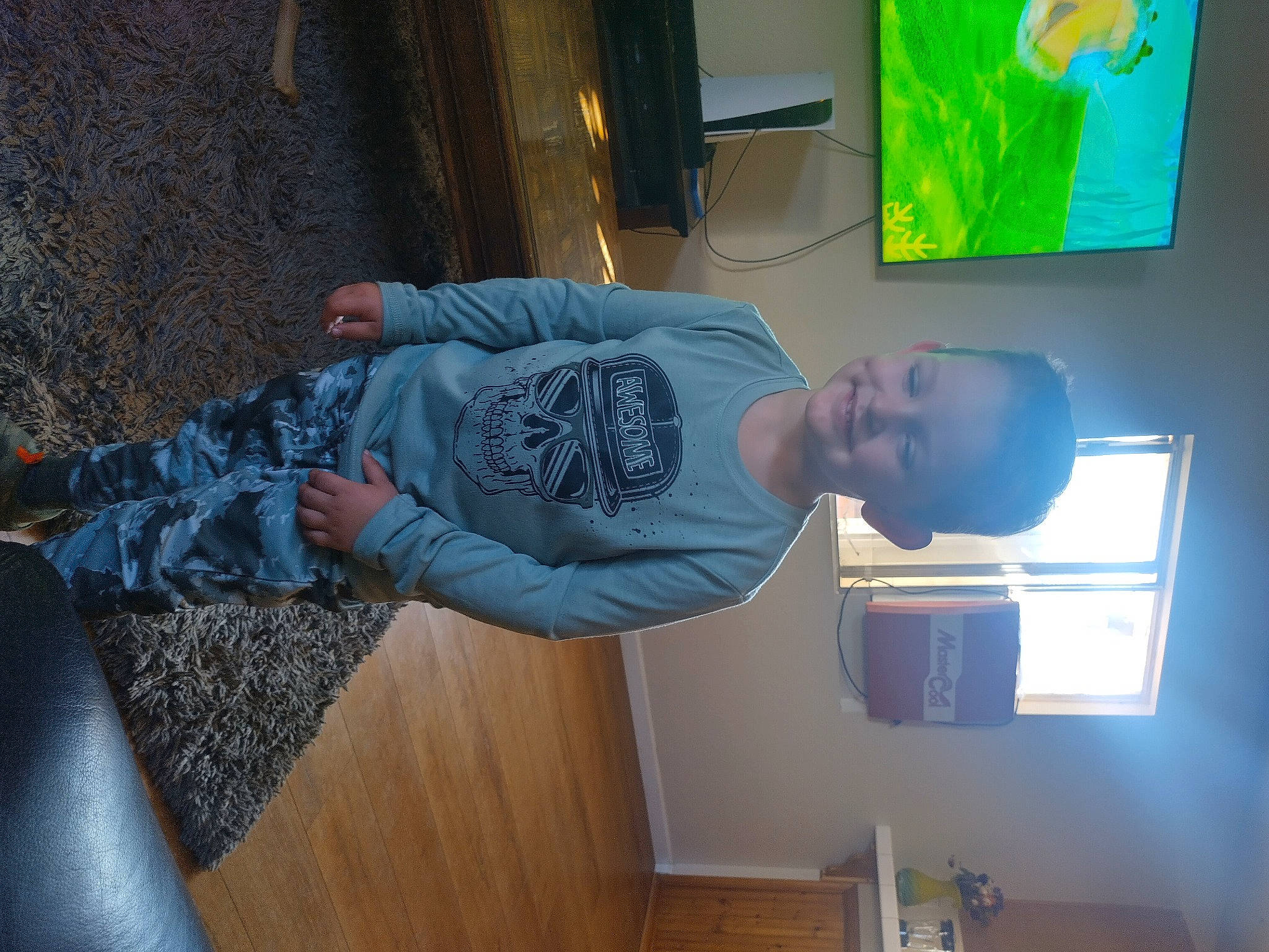 Troy is registered to the contest to win money with this photo: comfort, display_device, elbow, electric_blue, fun, hardwood, hat, joy, machine, person, room, t_shirt, visual_arts, wood, wrist