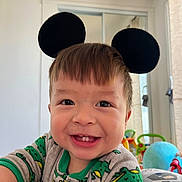 Neytan Calev Zepeda joined the competition — help win amazing prizes! toddler, child, smiling, mouse_ears, headband, dinosaur_pajamas, indoor, toy, playroom, happy, cute, baby, face, portrait, clothing, childhood, fun, colorful, person, home