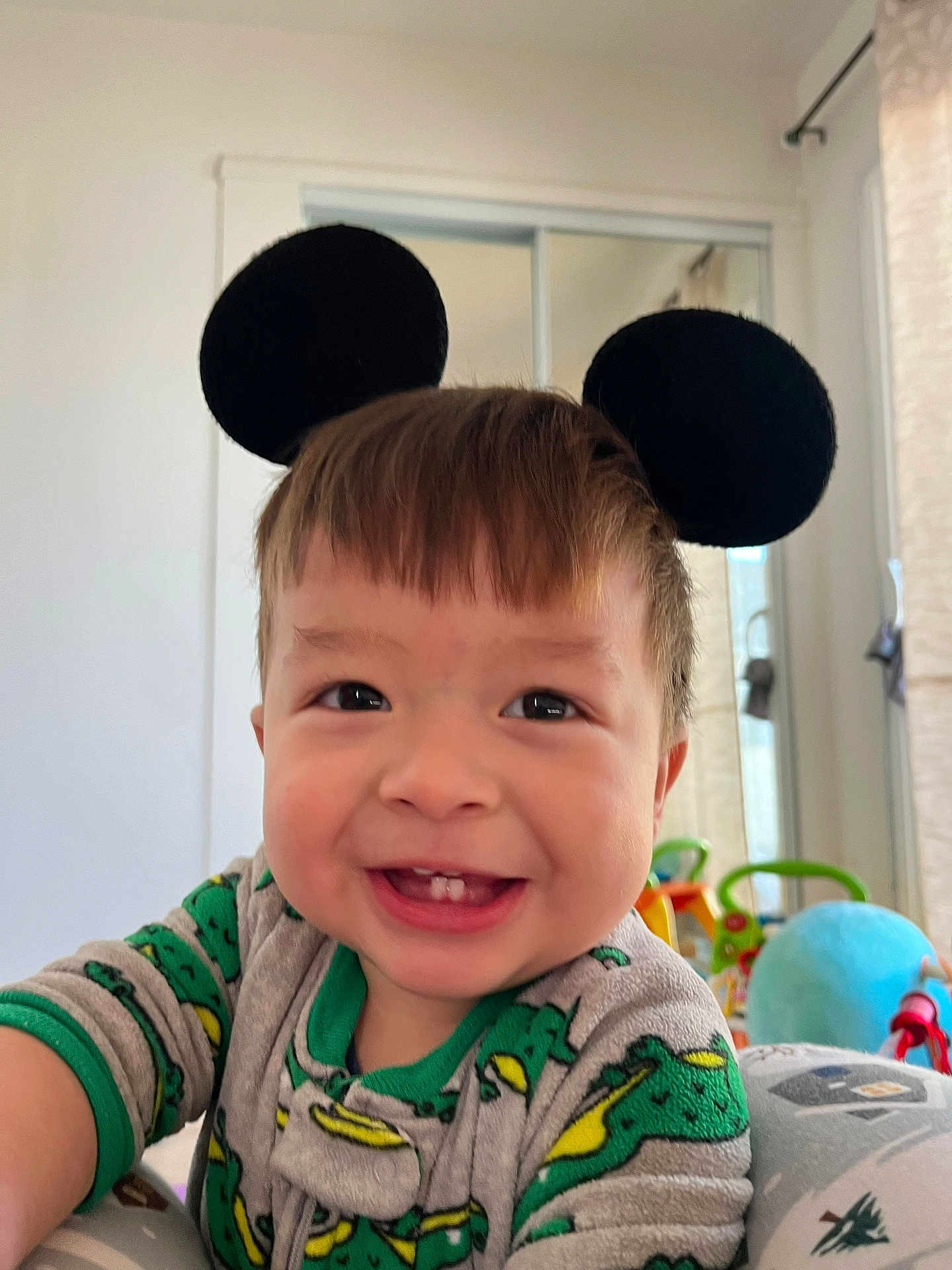 Neytan Calev Zepeda joined the competition — help win amazing prizes! toddler, child, smiling, mouse_ears, headband, dinosaur_pajamas, indoor, toy, playroom, happy, cute, baby, face, portrait, clothing, childhood, fun, colorful, person, home