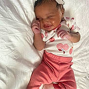 Kamora joined the competition — help win amazing prizes! baby, infant, child, smiling, sleeping, headband, bow, white_blanket, pink_pants, cherry_pattern, clothing, cute, lying_down, soft_texture, cozy, peaceful, portrait, indoors, person, newborn
