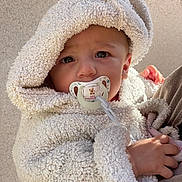 Julia participe au concours pour gagner de l'argent avec cette photo : baby, child, pacifier, hoodie, fluffy_clothing, hand, face, cute, infant, warm_clothing, portrait, closeup, young_child, skin, eyebrows, eyelashes, expression, outdoor, soft_texture, toddler