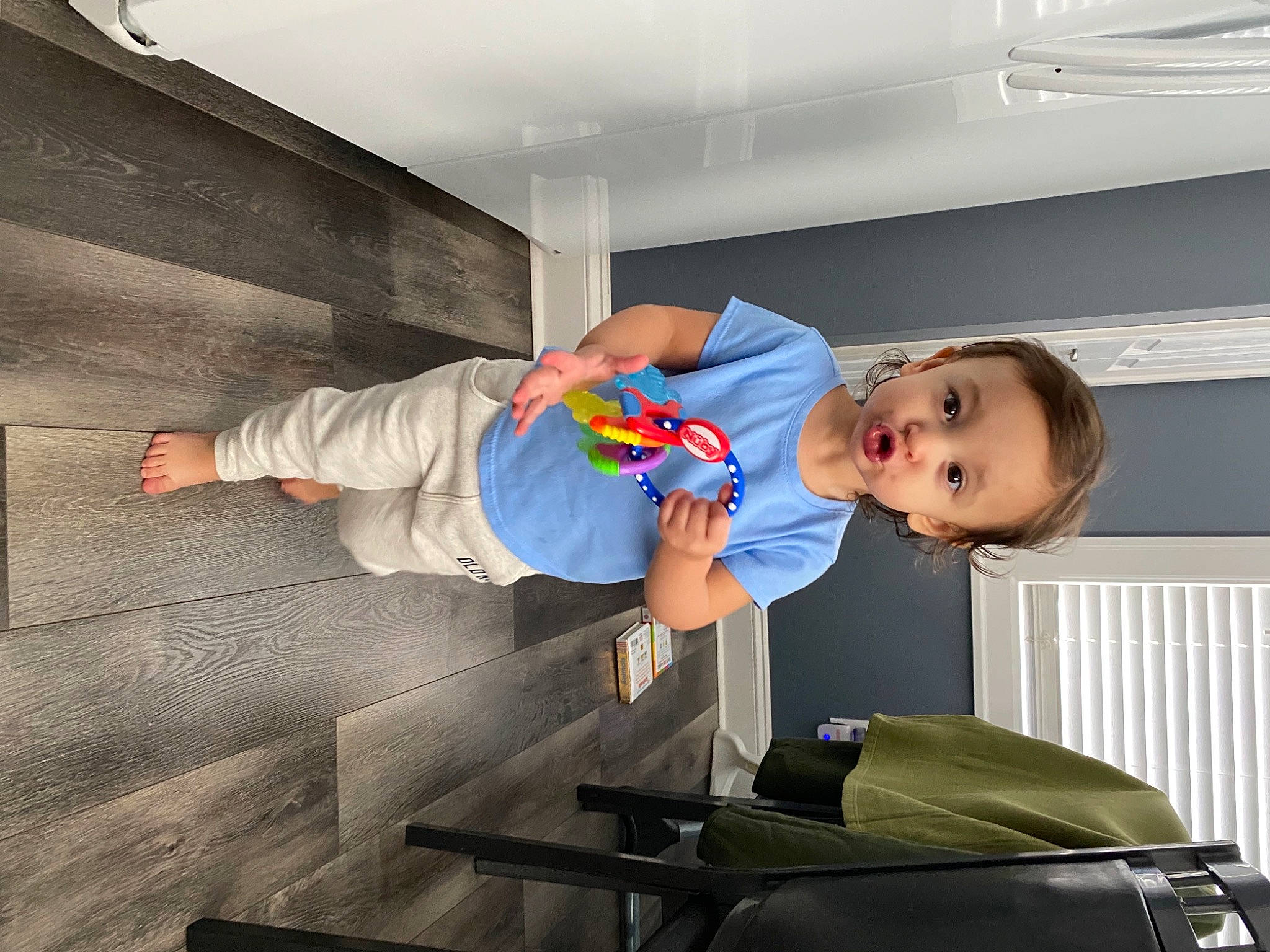 Kaya is registered to the contest to win money with this photo: baby, baby_toddler_clothing, bag, baggage, ceiling, child, comfort, composite_material, elbow, electric_blue, fun, joint, luggage_and_bags, person, room, sitting, sleeve, smile, standing, t_shirt