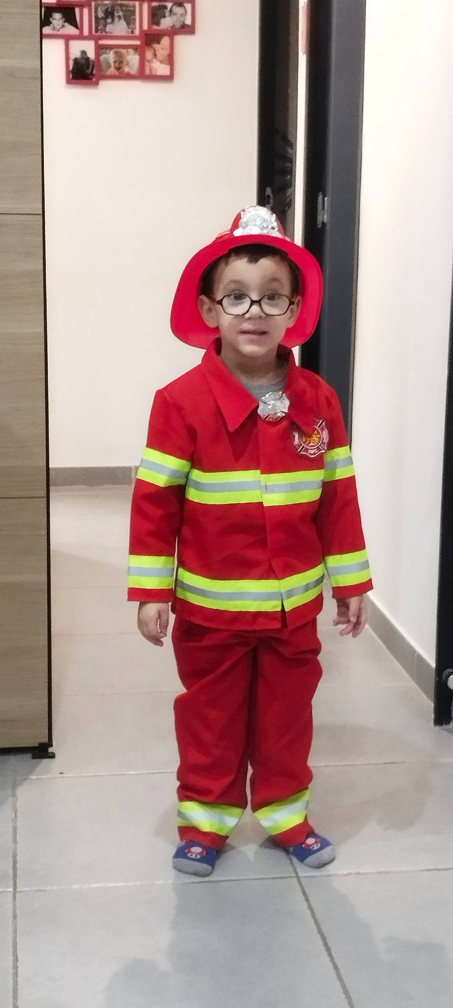 Melvyn participe au concours pour gagner de l'argent avec cette photo : costume, emergency_service, event, fictional_character, fire_department, firefighter, fun, hat, headgear, high_visibility_clothing, human_body, job, outerwear, person, personal_protective_equipment, red, service, sleeve, toddler, uniform