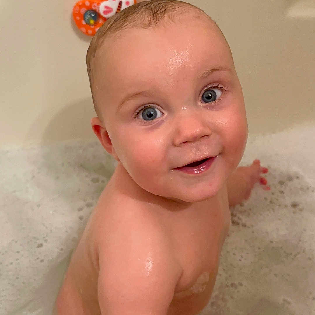 Brian is registered to the contest to win money with this photo: baby, bathing, bathroom, bathtub, bubble, face, happy, head, indoors, newborn, person, photography, portrait, room, shower, smile, tub