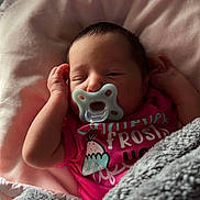 Amelia joined the competition — help win amazing prizes! baby, newborn, pacifier, blanket, pink_shirt, sleeping, indoor, cozy, closeup, person, child, soft_light, infant, resting, cute, portrait, warm, hands, face, peaceful