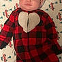 baby, infant, santa_hat, onesie, red_checkered, heart_pattern, blanket, red_trucks, green_trees, drool, cute, lying_down, holiday, christmas, face, child, indoors, clothing, happy, portrait