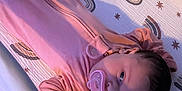 Jade joined the competition — help win amazing prizes! baby, changing_pad, child, cozy, cute, face, hands, head, indoor, infant, lying_down, onesie, pacifier, patterned_mat, person, pink_clothing, rainbow_pattern, sleepwear, soft_lighting, stars