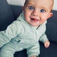 Alessio participe au concours pour gagner de l'argent avec cette photo : baby, child, infant, smiling, face, blue_eyes, onesie, sitting, indoor, couch, happy, cute, portrait, young, skin, expression, person, furniture, cozy, closeup