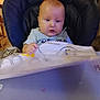 baby, child, high_chair, chicco, indoor, cloth, bib, dog, pet, furniture, person, table, curious, seat, floor, wood, tile, hand, face, expression