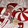 Kyla joined the competition — help win amazing prizes! baby, infant, sleeping, santa_hat, christmas, holiday, blanket, pillow, ornaments, red, white, decorations, wooden_sign, star, sock_booties, soft_toys, festive, cute, bed, nap
