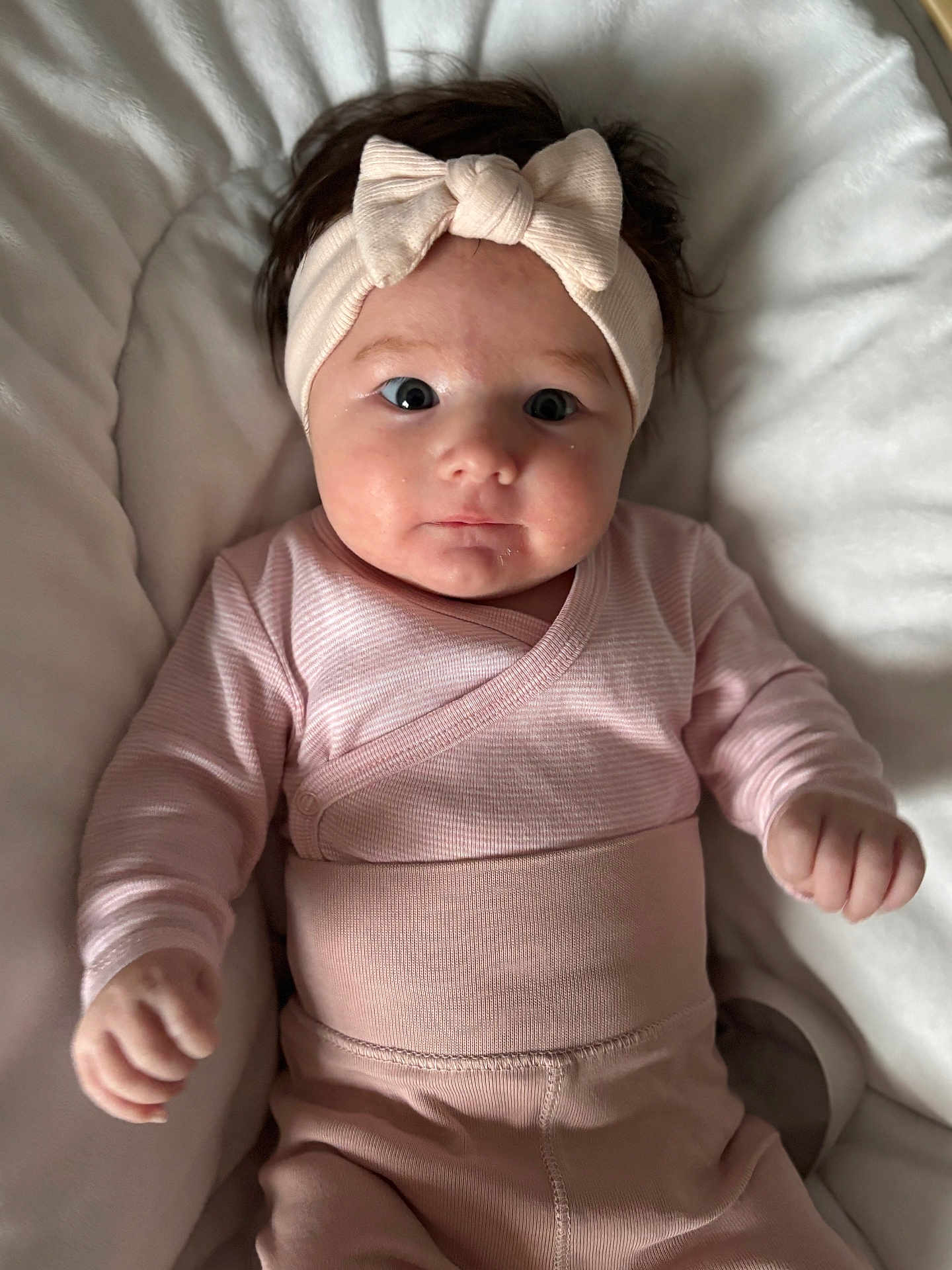 Kyara participe au concours pour gagner de l'argent avec cette photo : baby, infant, headband, bow, pink_clothing, cute, face, eyes, hands, lying_down, blanket, soft, cushion, indoors, portrait, child, adorable, newborn, skin, expression