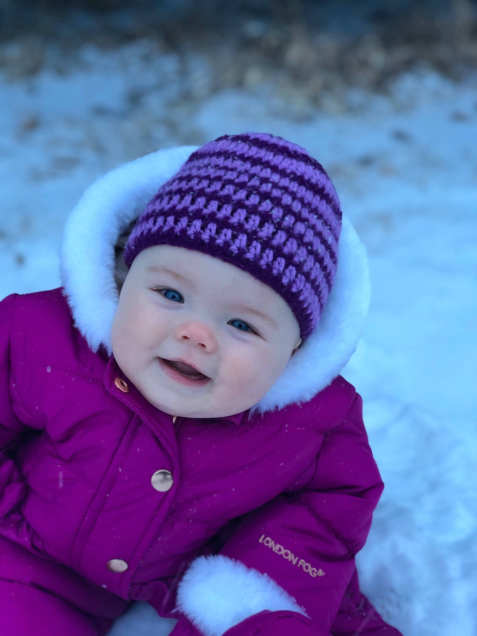 Guinevere is registered to the contest to win money with this photo: baby, beanie, bonnet, cap, child, hat, headgear, headwear, knit_cap, knitting, person, pink, playing_in_the_snow, purple, snow, toddler, winter, wool, woolen