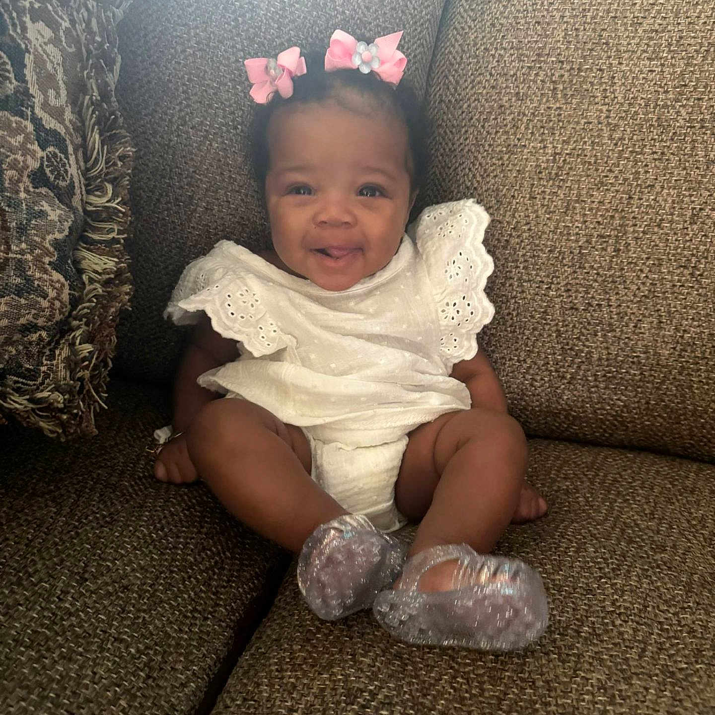Kaelyx is registered to the contest to win money with this photo: adorable, baby, child, comfortable, couch, cute, decorative_pillow, happy, home, indoor, infant, person, pink_bows, portrait, sitting, smile, sparkly_shoes, textured_fabric, white_dress, young_child