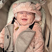 Gracie-Mae is registered to the contest to win money with this photo: baby, smiling, infant, pink_hoodie, car_seat, seatbelt, fluffy_clothing, cute, child, baby_face, happy, indoors, padded, safety, warm_clothing, hood, plush, newborn, transport, comfort