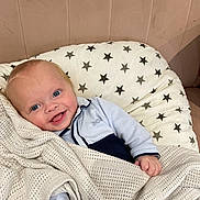 Albie joined the competition — help win amazing prizes! baby, smiling, blue_eyes, blanket, knitted_blanket, cushion, star_pattern, infant, cute, comfort, indoors, soft_furniture, child, portrait, happy, cozy, person, head, clothing, pale_pink_background