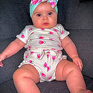 Guiliana a rejoint le concours — aidez-le/la à gagner de superbes lots ! arms, baby, child, chubby, comfort, couch, cute, expression, face, floral_headband, indoors, infant, legs, onesie, patterned_clothing, pink, portrait, seated, skin, white