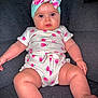 arms, baby, child, chubby, comfort, couch, cute, expression, face, floral_headband, indoors, infant, legs, onesie, patterned_clothing, pink, portrait, seated, skin, white