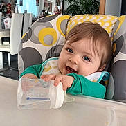 Wayan a rejoint le concours — aidez-le/la à gagner de superbes lots ! baby, bib, bottle, chair, child, clock, cute, dining_table, feeding, furniture, happy, high_chair, home, indoor, infant, person, plant, portrait, smile, young_child