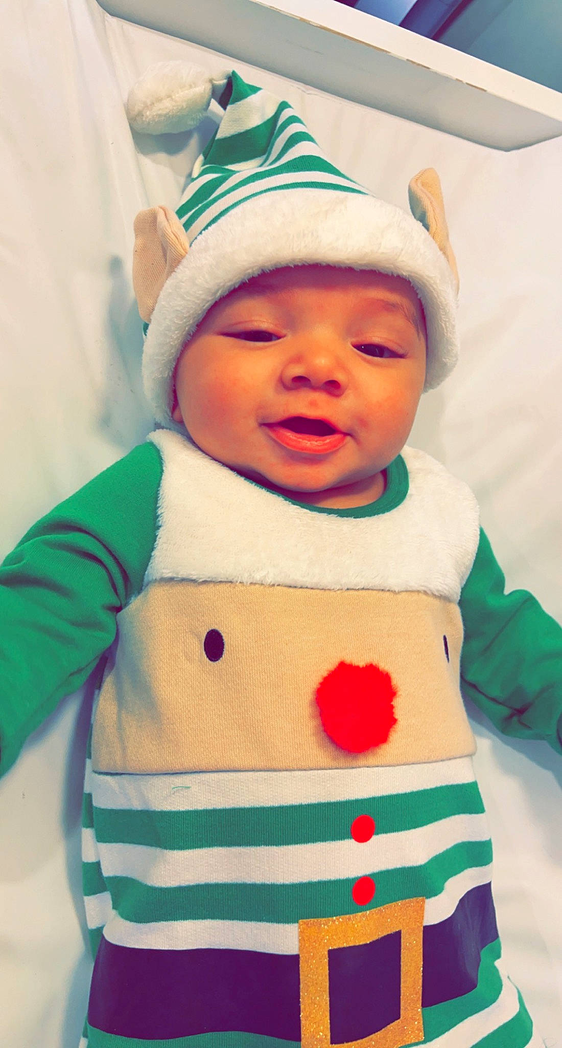 Luciano is registered to the contest to win money with this photo: baby, baby_toddler_clothing, cap, cheek, child, event, facial_expression, fictional_character, fun, green, happy, headwear, hood, organ, pattern, person, pink, sleeve, smile, t_shirt