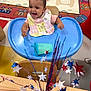 Olivia joined the competition — help win amazing prizes! baby, high_chair, bib, smiling, happy, child, toy, table, chair, floor, carpet, stars, decoration, red, white, blue, indoor, playroom, person, celebration