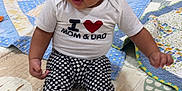 Olivia joined the competition — help win amazing prizes! baby, child, infant, sitting, headband, red_bow, white_shirt, checkered_pants, ruffles, play_mat, mirror, toys, orange_wall, floor, indoor, cute, smiling, clothing, footwear, person