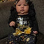 Trinity is registered to the contest to win money with this photo: baby, infant, child, new_year, holiday, festive_clothing, black_outfit, gold_bow, headband, christmas_tree, couch, indoors, celebration, sitting, portrait, cute, face, person, holiday_lights, cozy