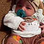 baby, pacifier, bow, headwrap, blanket, clothing, brown, cozy, infant, cute, sitting, child, warm, soft, relaxed, indoors, person, portrait, toddler, cute_face